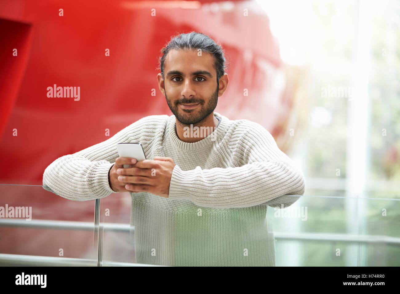 Asian male university student holding smartphone, portrait Banque D'Images