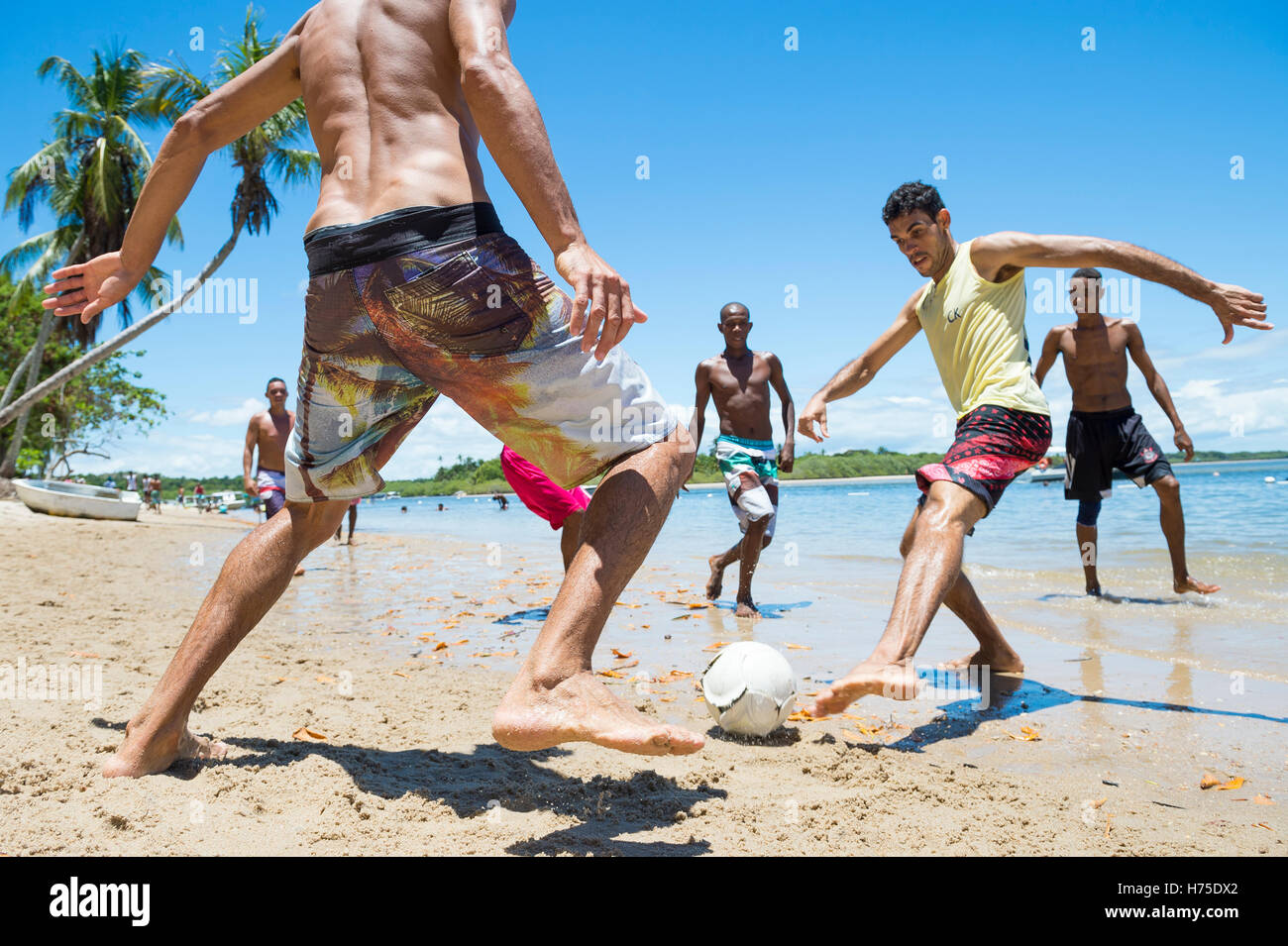 BAHIA, BRÉSIL - 7 février 2016 : un groupe de jeunes hommes musclés brésilien jouer au foot de plage sur le bord d'une plage éloignée. Banque D'Images