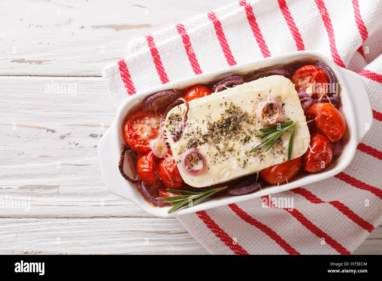 La nourriture grecque : Feta au four avec tomates et oignons dans le plat de cuisson horizontale vue du dessus. Banque D'Images