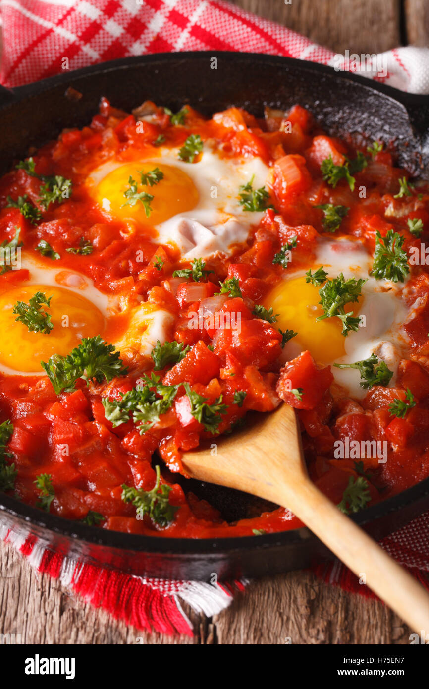 Shakshuka œufs frits avec sauce tomate fermer jusqu'à la poêle. La verticale Banque D'Images