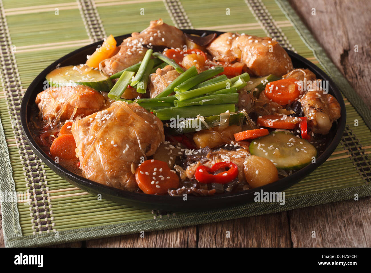 Cuisine coréenne : Dakjim au poulet avec légumes et les graines de sésame sur une plaque horizontale. Banque D'Images