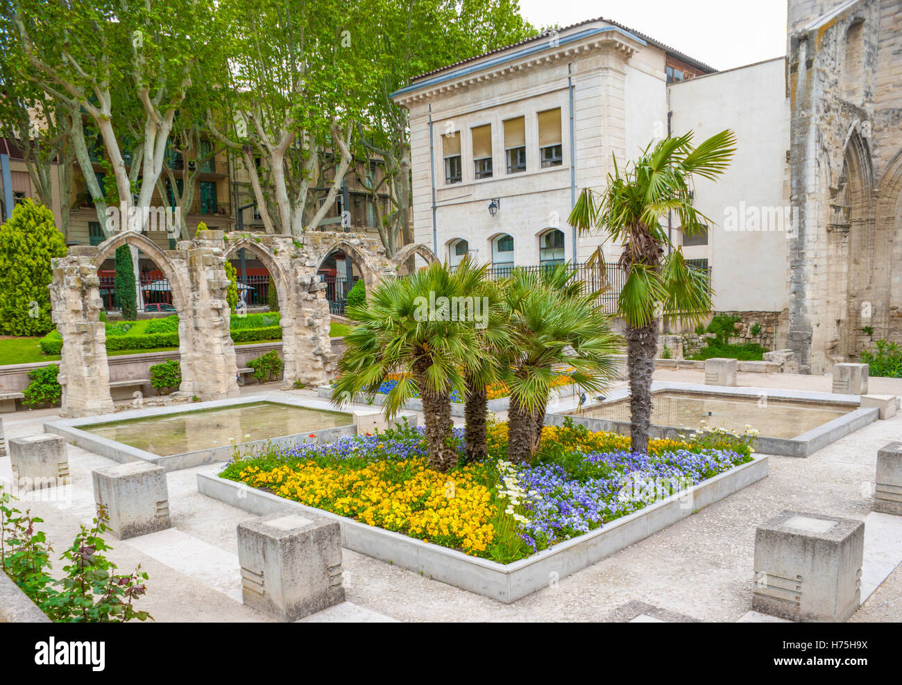 Le parterre de fleurs devant les ruines du cloître du monastère bénédictin, situé dans le petit jardin, à côté du temple Saint-Martial, Avignon, France Banque D'Images