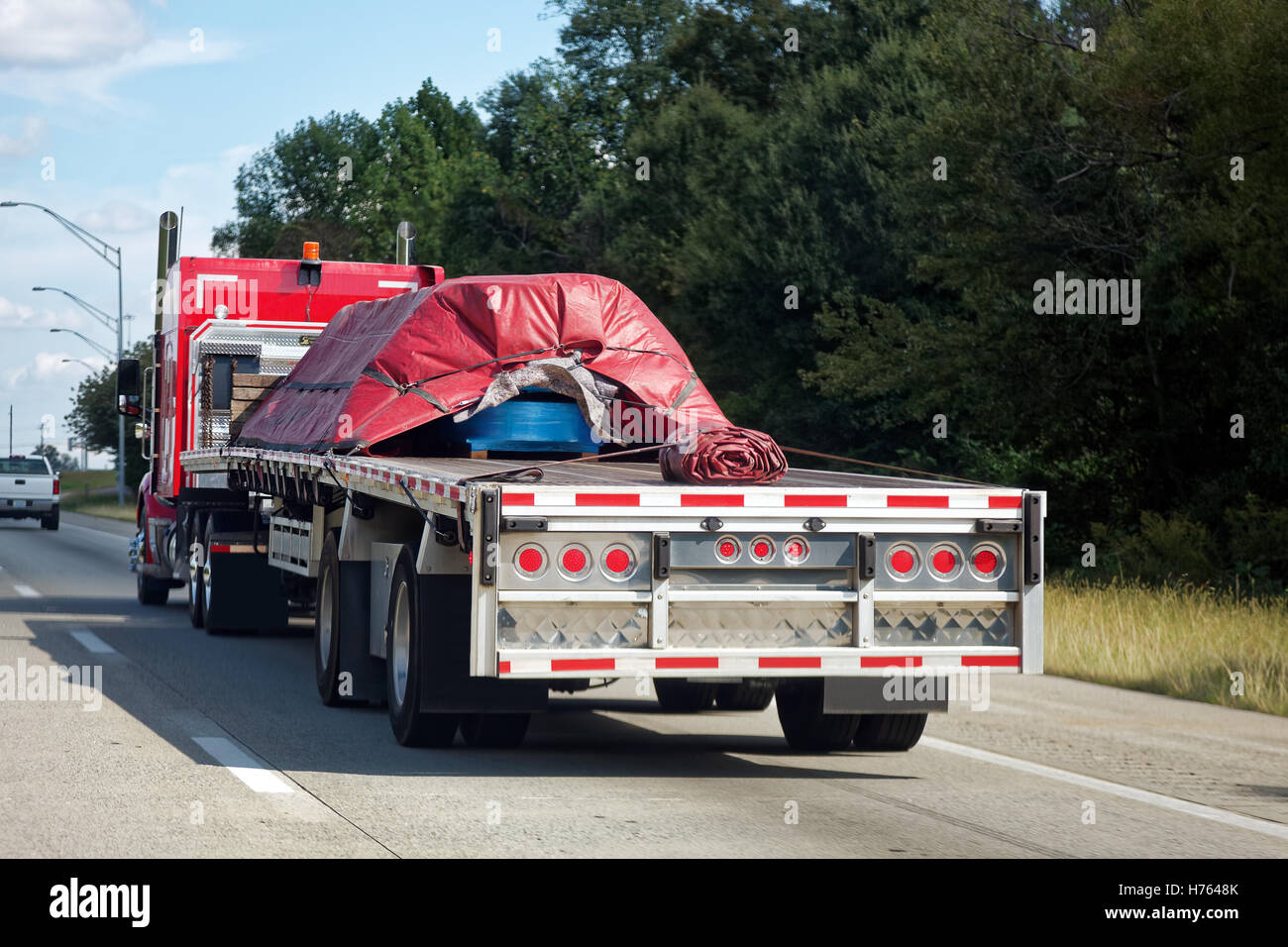 Freight couvert par une bâche rouge sur semi truck on highway Banque D'Images