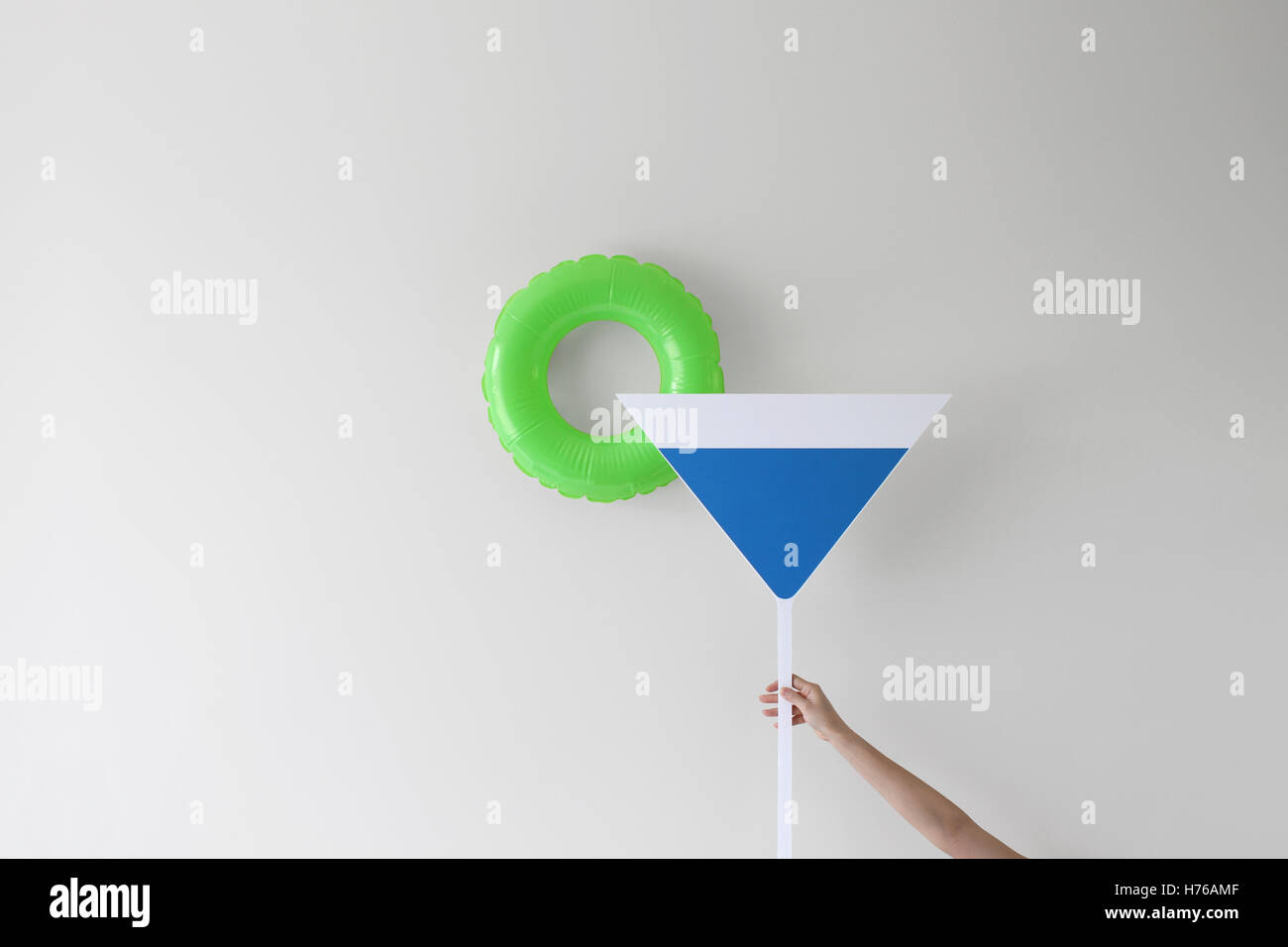 Main tenant un verre à cocktails conceptuel Banque D'Images