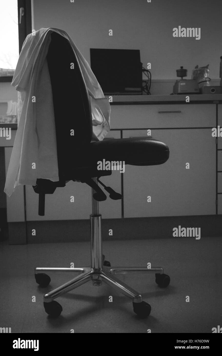 Chaise de laboratoire vide avec blouse de laboratoire. Fin des travaux concept Banque D'Images