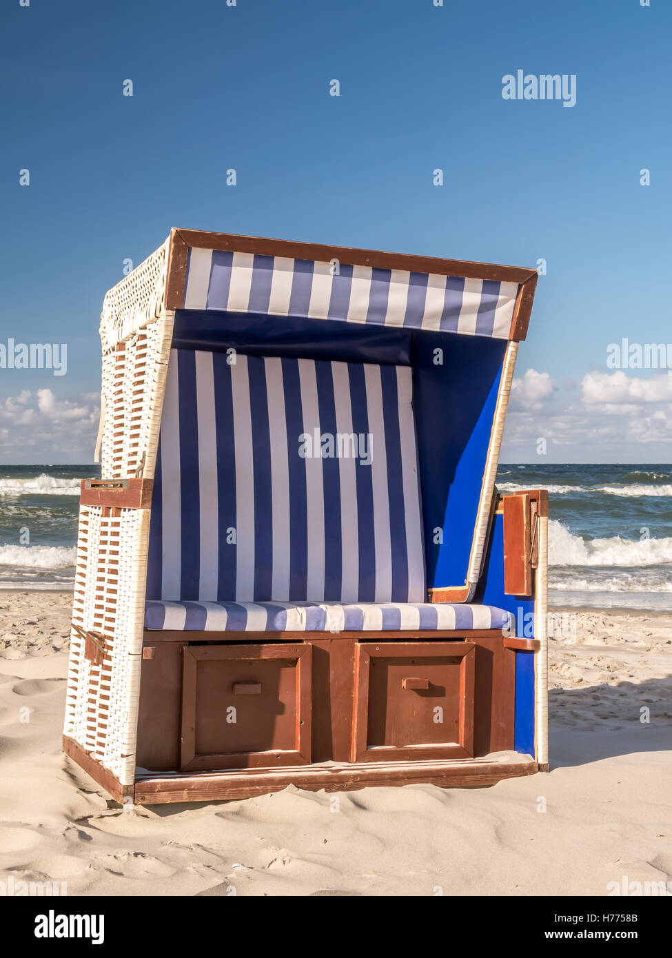 Chaise de plage en osier couvert vide tourné contre le ciel et mer Banque D'Images