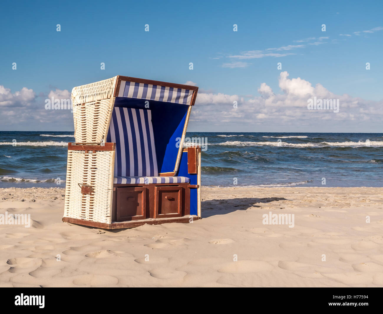 Chaise de plage en osier couvert vide tourné contre le ciel et mer Banque D'Images
