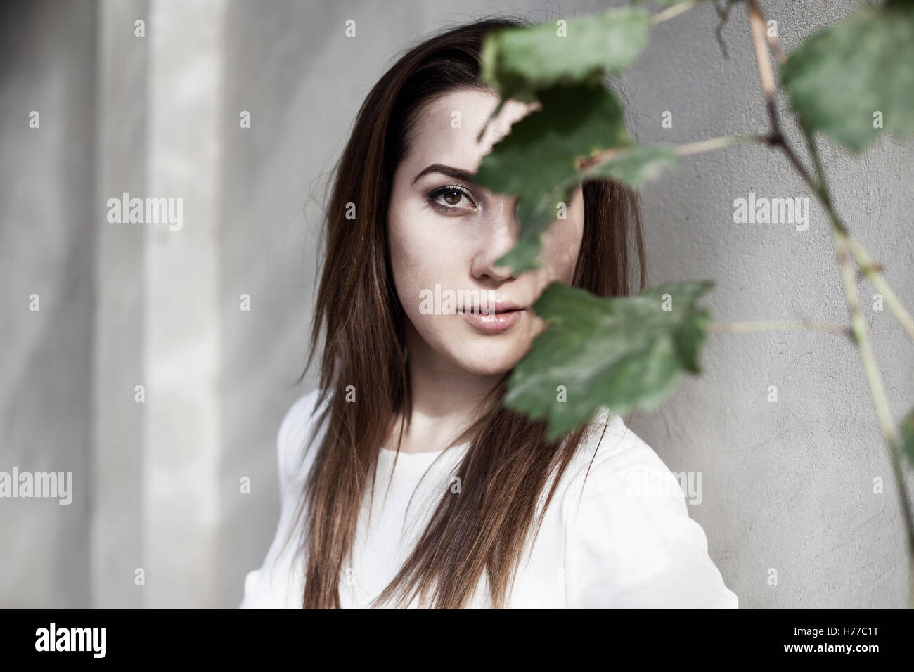 Portrait d'une femme de la face cachée par des feuilles Banque D'Images