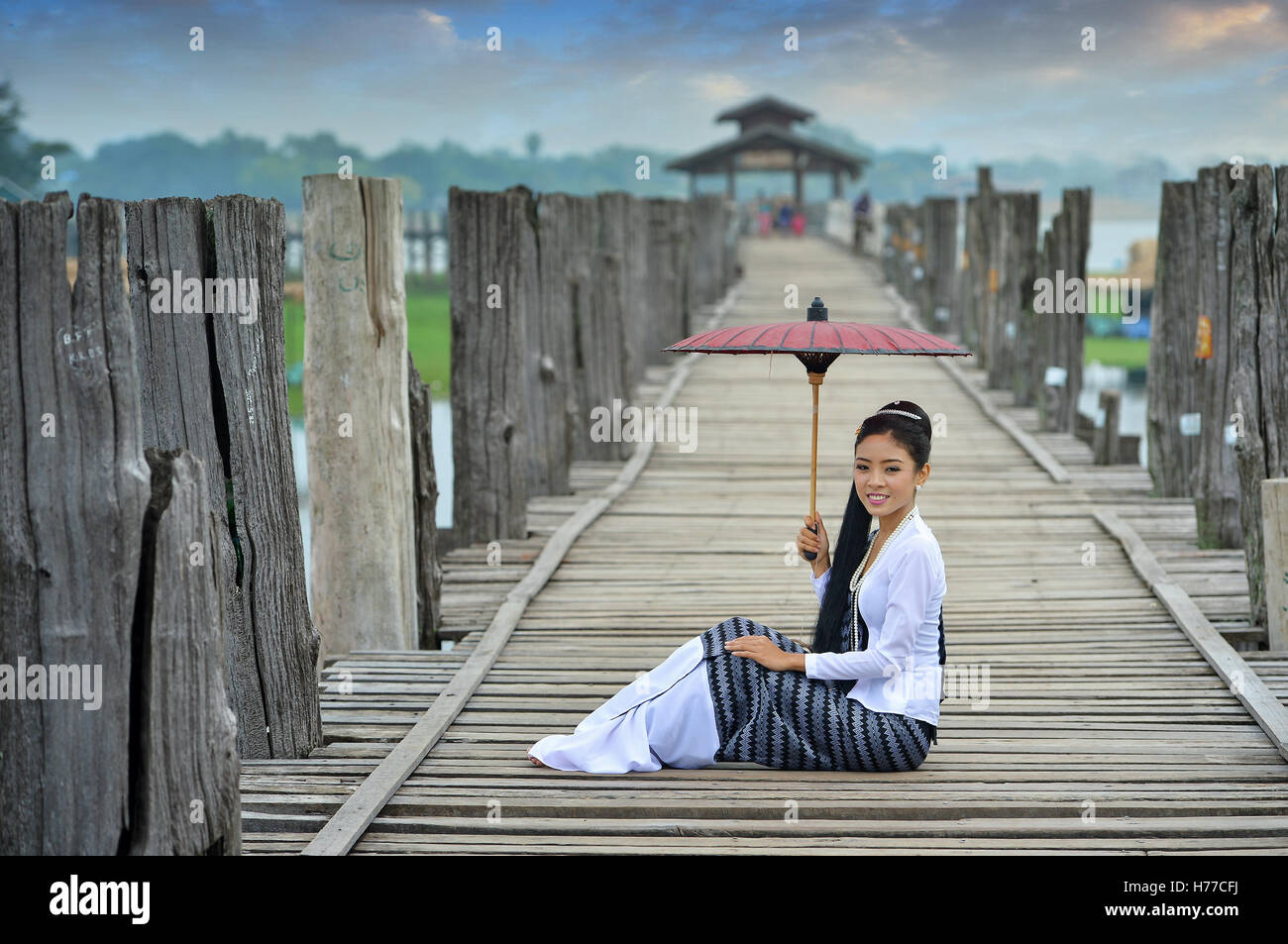 Portrait d'une femme assise sur le pont avec un parasol, Mandalay, Myanmar Banque D'Images