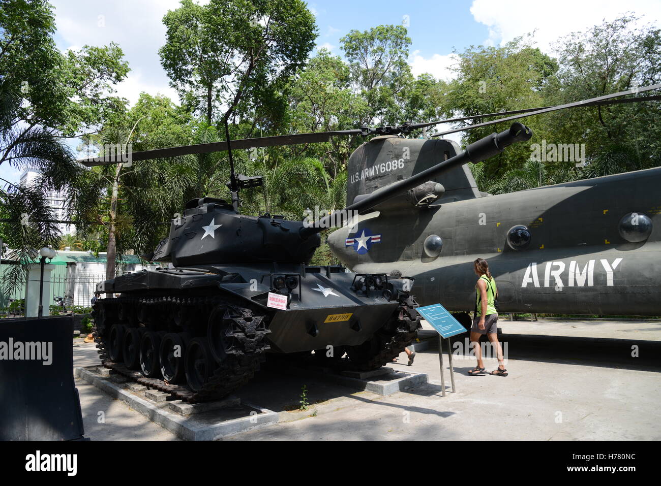 Deux visiteurs d'oeil à un réservoir de l'armée américaine et l'hélicoptère au Musée des débris de guerre, Ho Chi Minh Ville (Saigon), Vietnam Banque D'Images