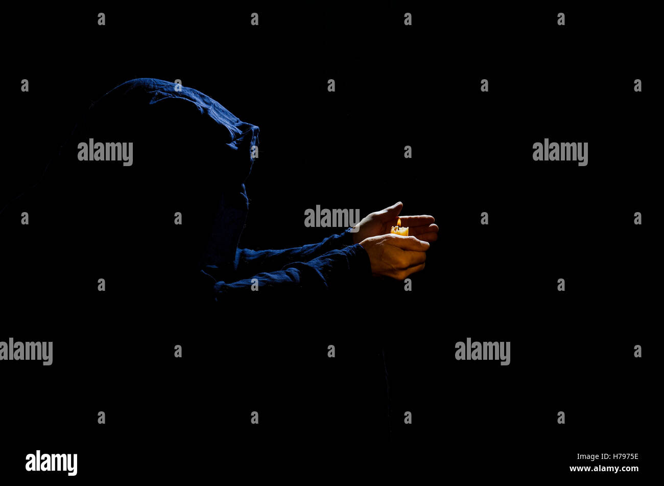 Moine avec bougie dans l'obscurité. Banque D'Images