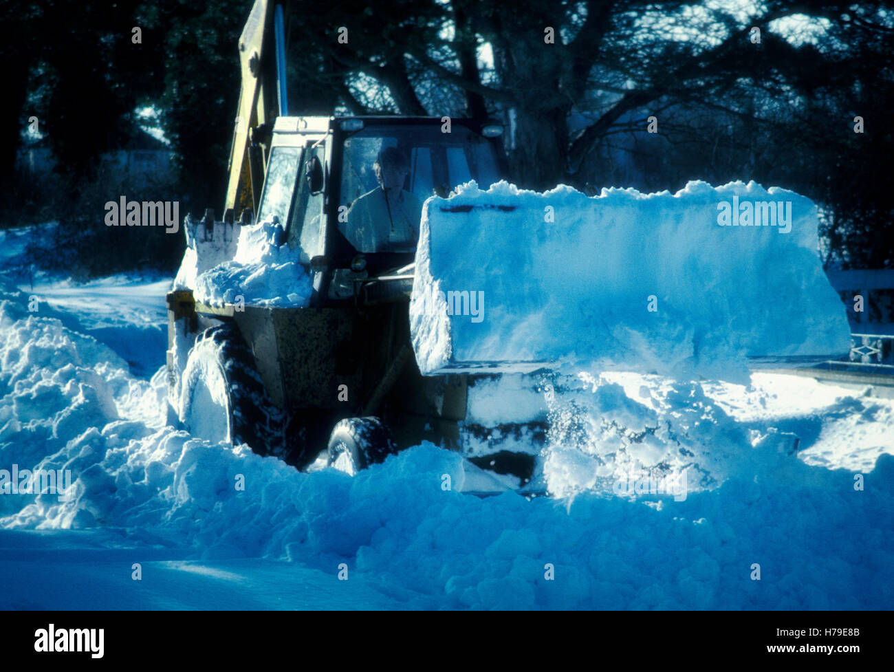 Mechanical digger clearing bloqué voies entre le blizzard de 1982, dans laquelle un fort vent d'est laissé les domaines principalement ciel dégagé, et la neige tombée jusqu'à une hauteur de 2 mètres sur les routes du Sud - Nord laissant alors infranchissable. Ce sont tourné à environ 4 milles au nord de Sant Esteve Sesrovires, comté de Meath, en Irlande. Banque D'Images