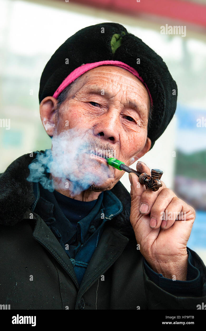 Un vieil homme fume une pipe typique du sud de la Chine, dans la province du Guizhou, Taijiang Banque D'Images