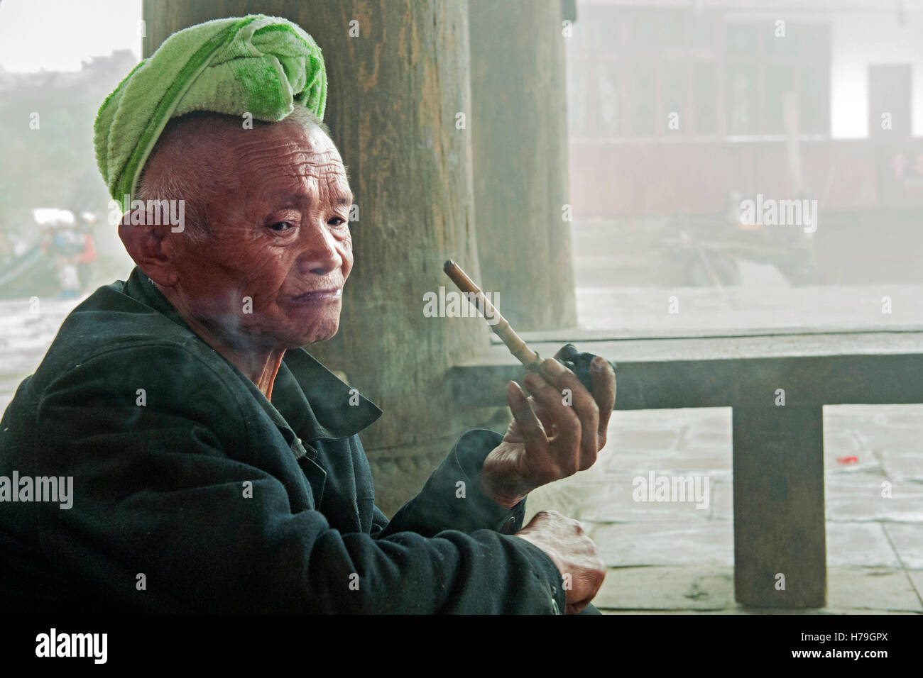 Un vieil homme fume la pipe dans l'Tang'un village Zhaoxing, dans la province de Guizhou, Chine Banque D'Images