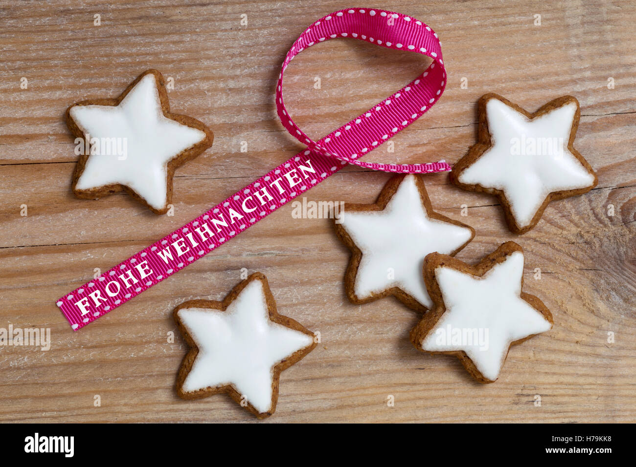 Étoiles à la cannelle sur bois avec Frohe Weihnachten (en allemand) joyeux noël ruban cadeau. Banque D'Images