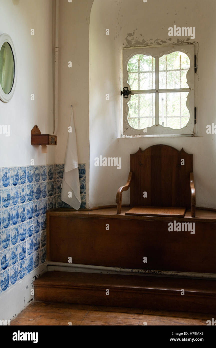 Siège de toilette en bois ancien avec miroir ci-dessous mur carrelé bleu 18e siècle château de Cussigny, Côte d'Or, Bourgogne, France Banque D'Images