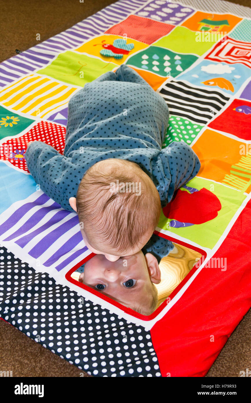 Bébé Garçon jouant sur un tapis de jeu Banque D'Images