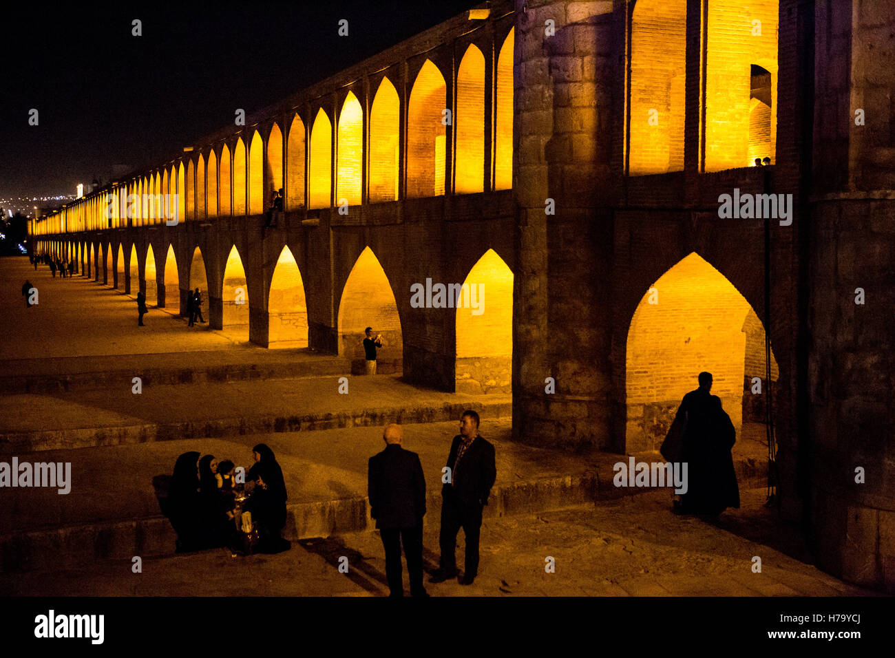 Les gens se reposent au si-o-se pol silhouettes contre pont arches jaune Banque D'Images