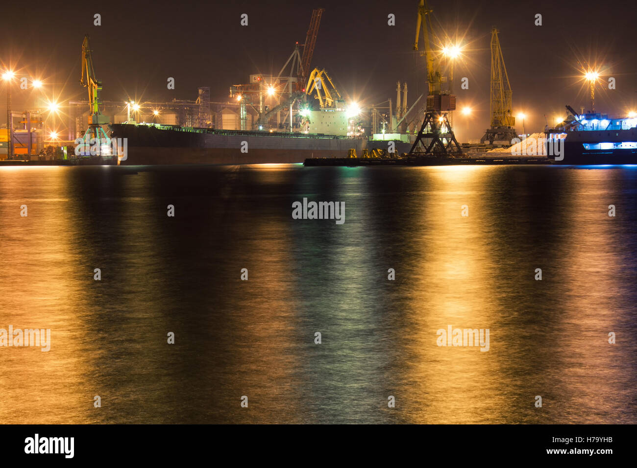 Bateau est amarré au terminal à conteneurs du port d'Odessa, Ukraine. Feux de la grue sont sur l'arrière-plan. Vue de nuit photo Banque D'Images