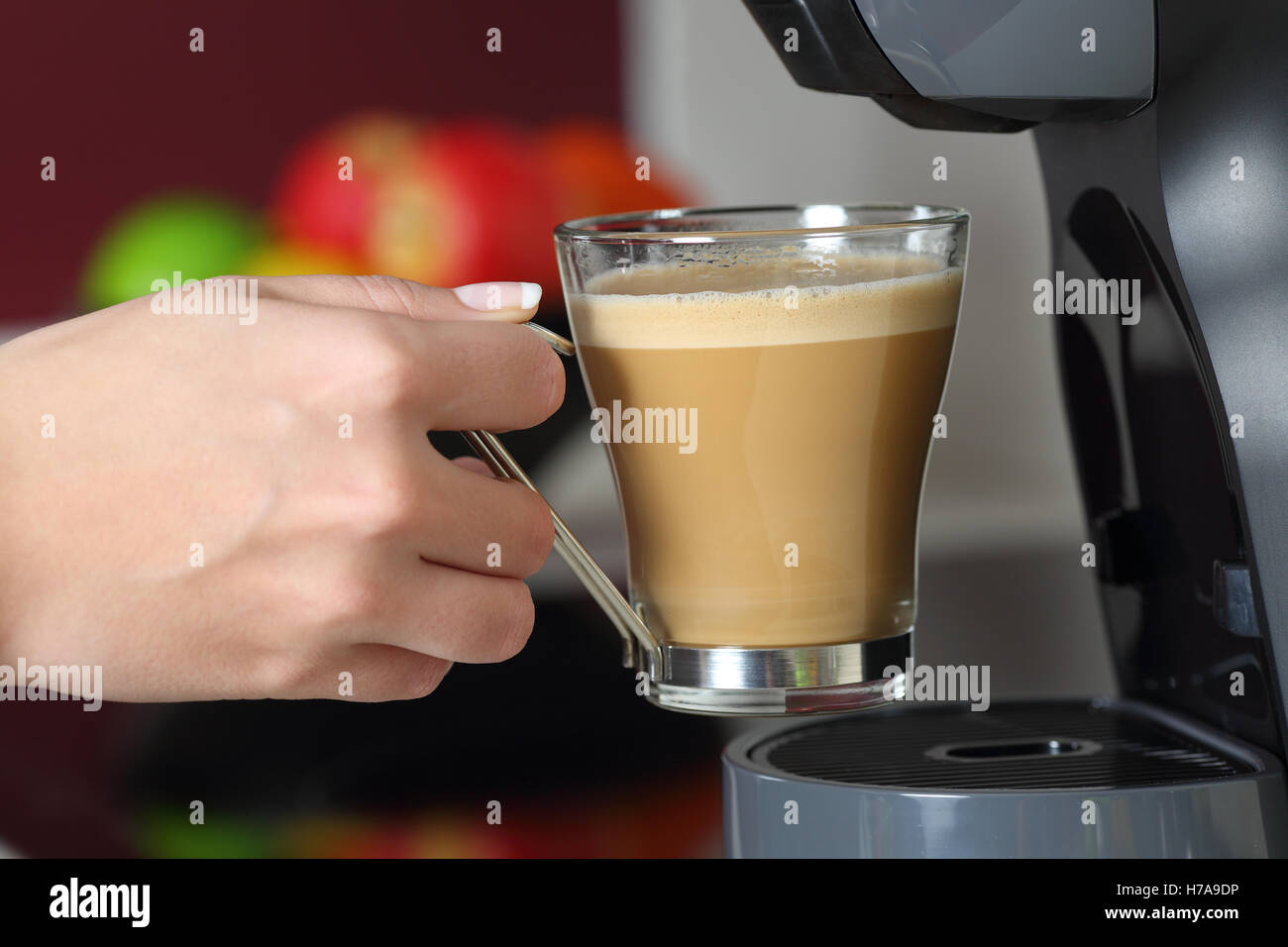 Close up of a woman holding a cup dans un café dans la cuisine à la maison Banque D'Images