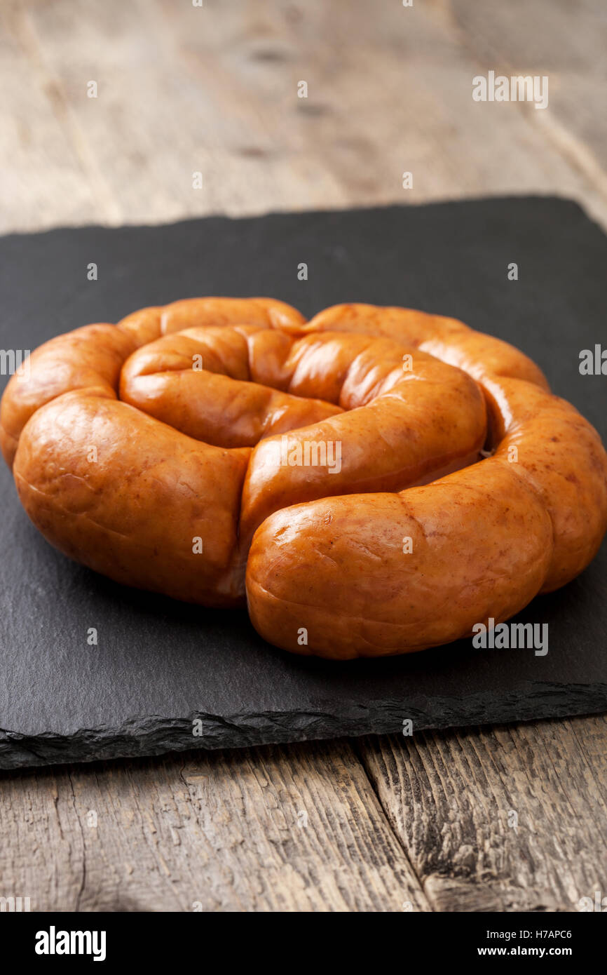 Saucisse fumée bague sur fond noir en noir Banque D'Images