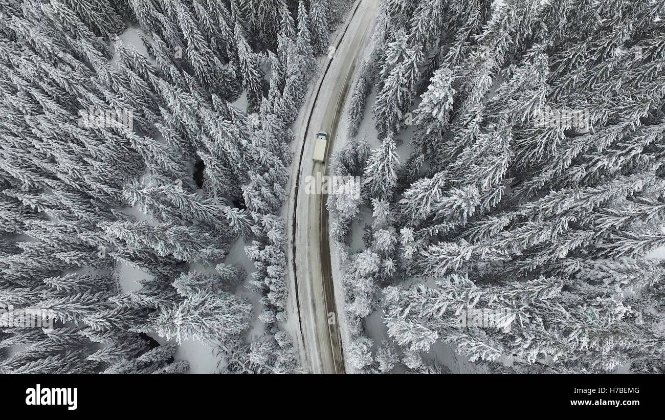 La neige et la route d'hiver gelé avec une voiture en mouvement sur elle. Banque D'Images