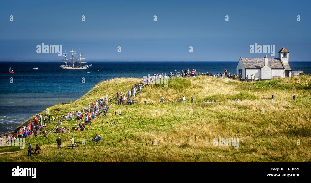 Les spectateurs à regarder la course des grands voiliers de Seaton Sluice Banque D'Images