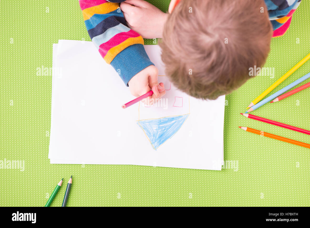 Dessin enfant une maison avec des crayons de couleur sur papier blanc. Concept de l'apprentissage de la petite enfance, l'éducation et la créativité. fun Banque D'Images