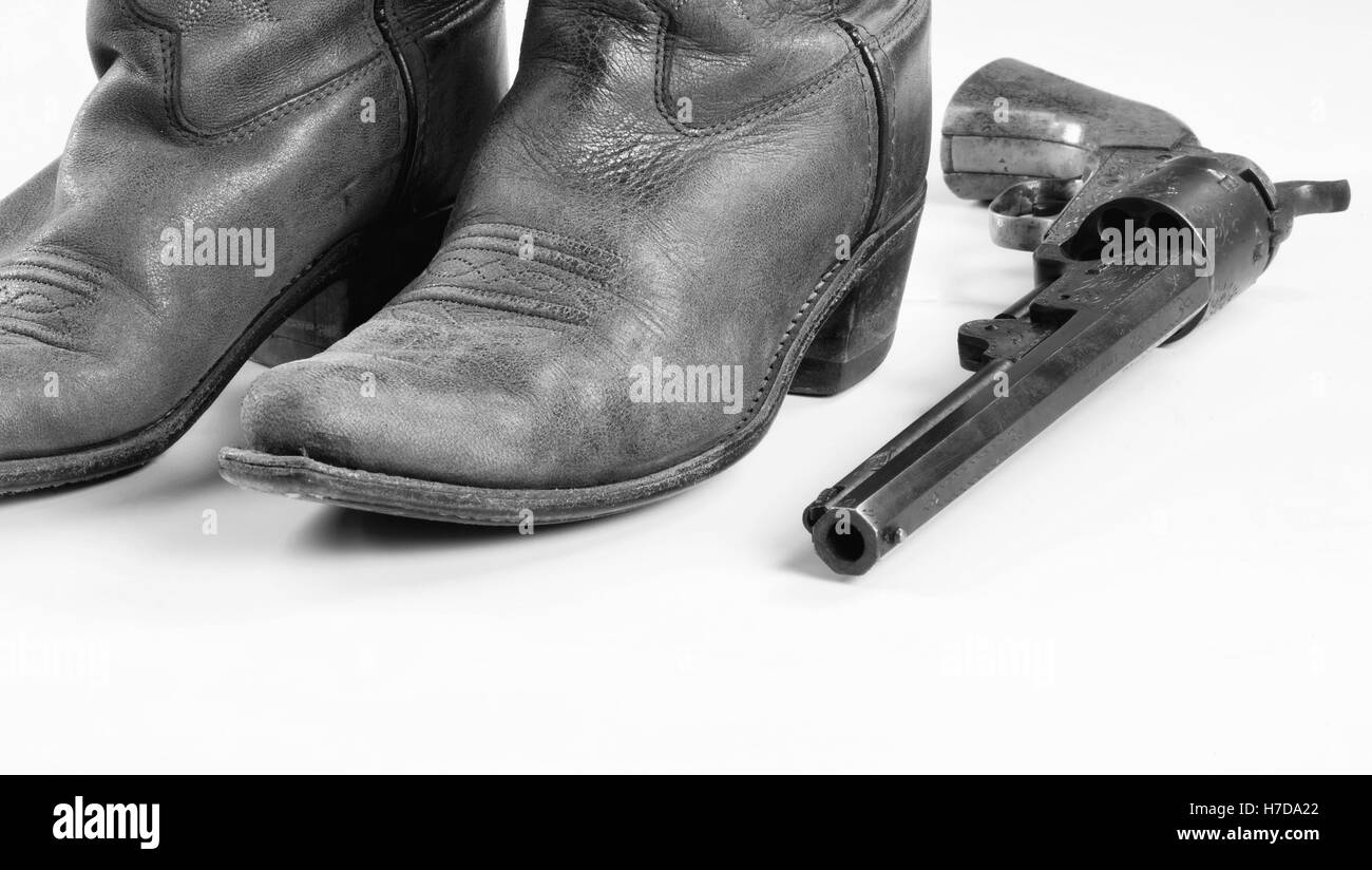 Bottes de cowboy et vieux pistolet de cow-boy en noir et blanc avec des prix pour votre type.. Banque D'Images