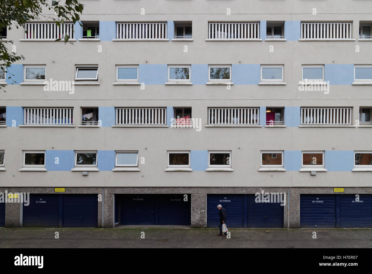 Bâtiment moderne des années 60 avec des vérandas avec l'homme panier inoffensif montrant classe ouvrière vivant sous forme graphique Banque D'Images