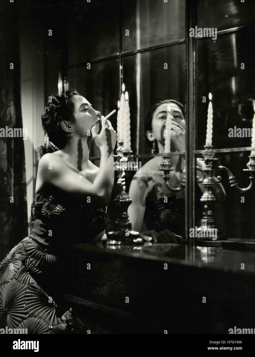 Femme allume une cigarette à partir de la bougie, Italie Banque D'Images