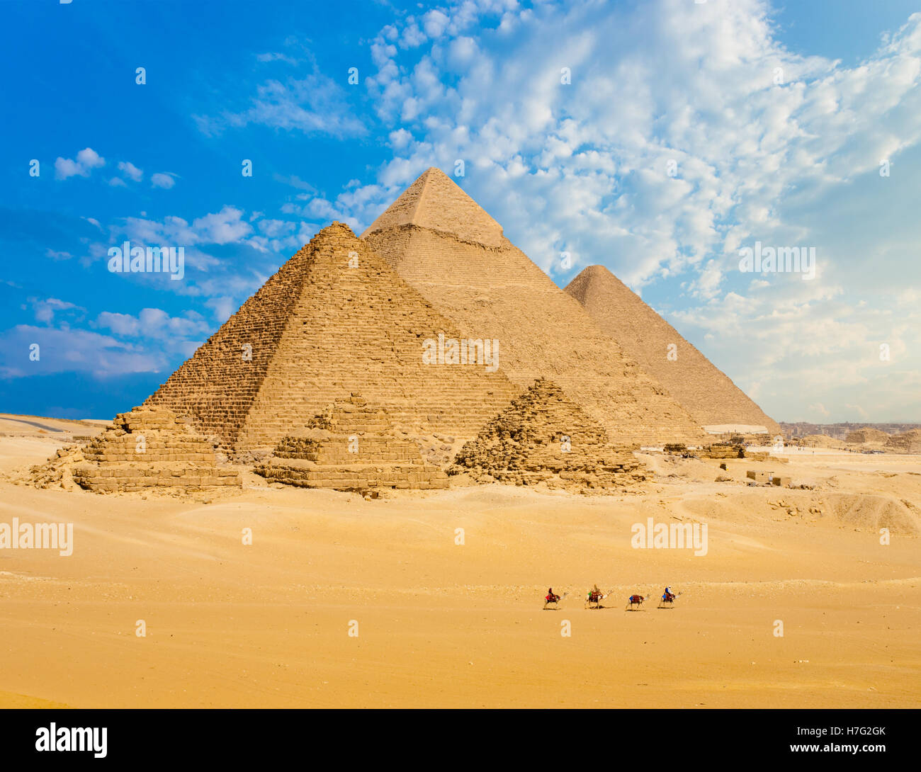 Tous les pyramides égyptiennes de distance avec rangée de chameaux marcher en premier plan dans la région de Giza, Le Caire, Égypte. Téléobjectif large copy space Banque D'Images