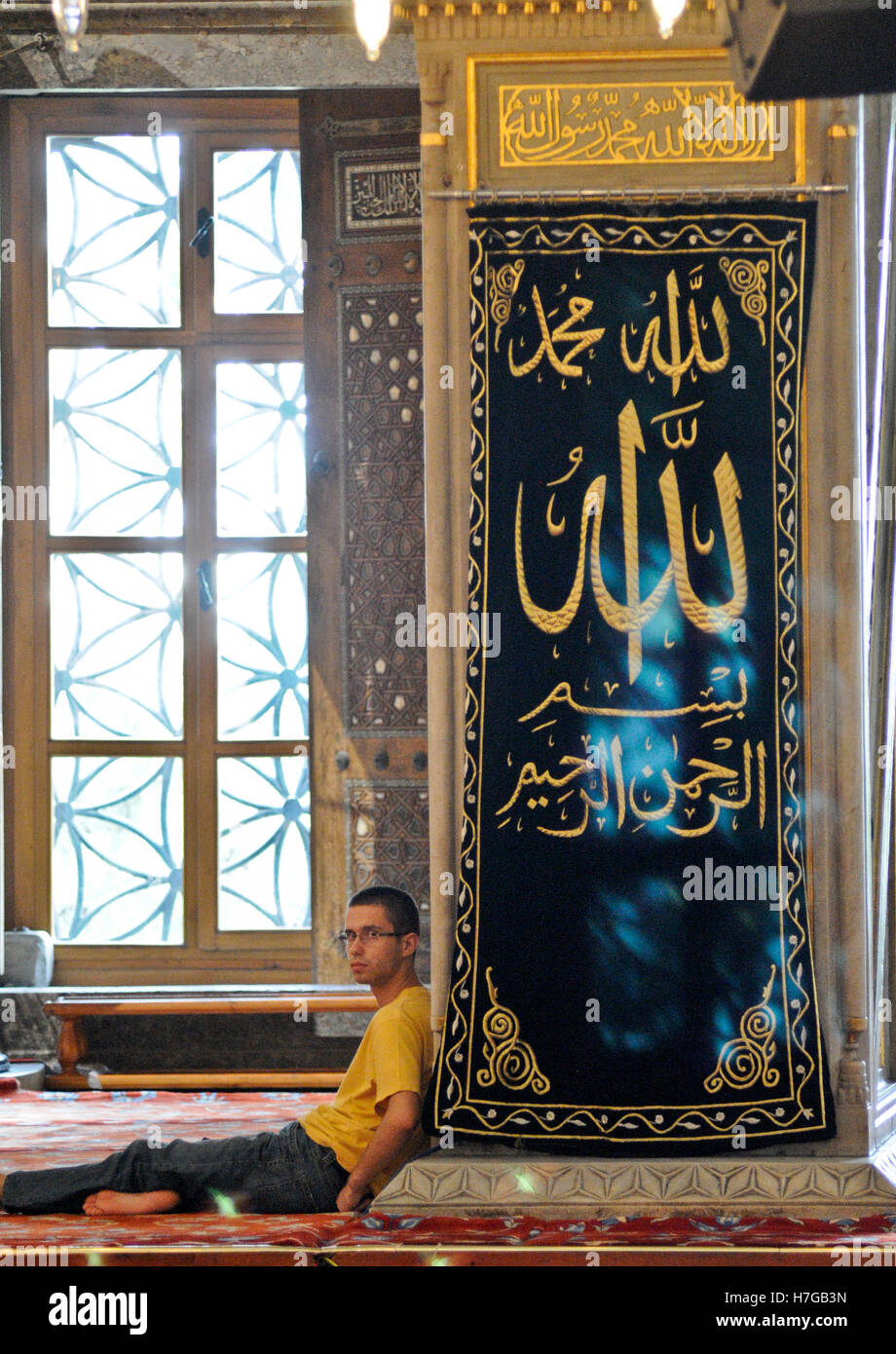 Repos à l'intérieur de l'homme musulman sur la Mosquée Bleue, Istanbul, Turquie Banque D'Images