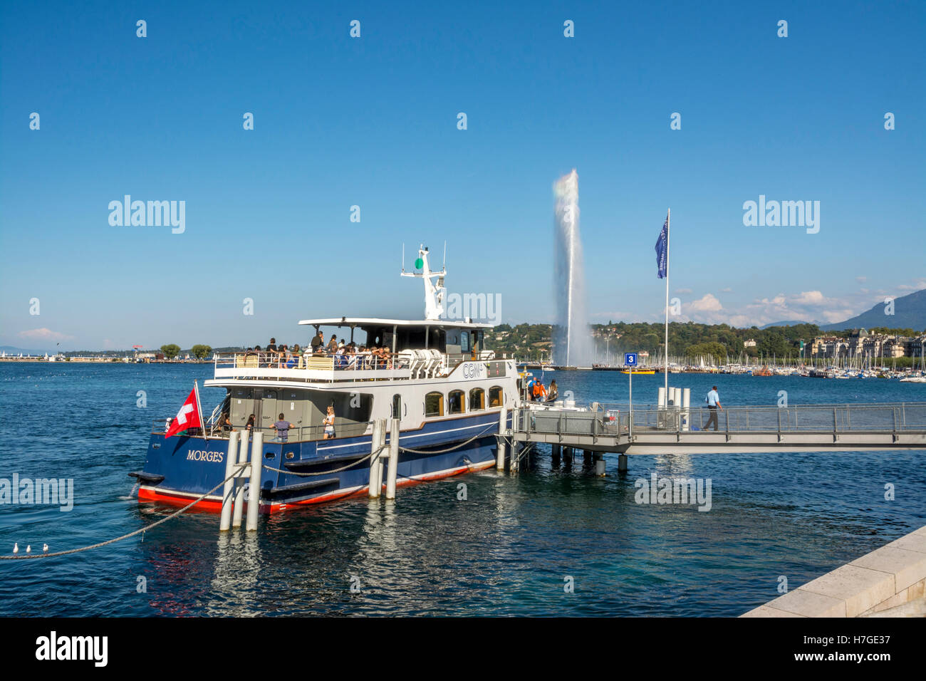 Bateau de croisière avec pavillon suisse amarré près de Jet d'eau dans le lac Léman, Suisse Banque D'Images