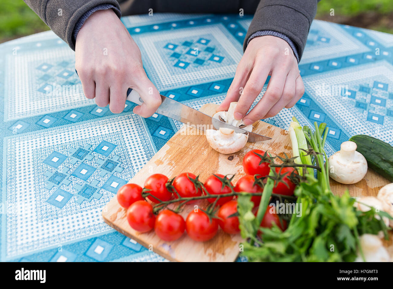 Couper les mains des femmes légumes frais sur planche de bois, close-up Banque D'Images