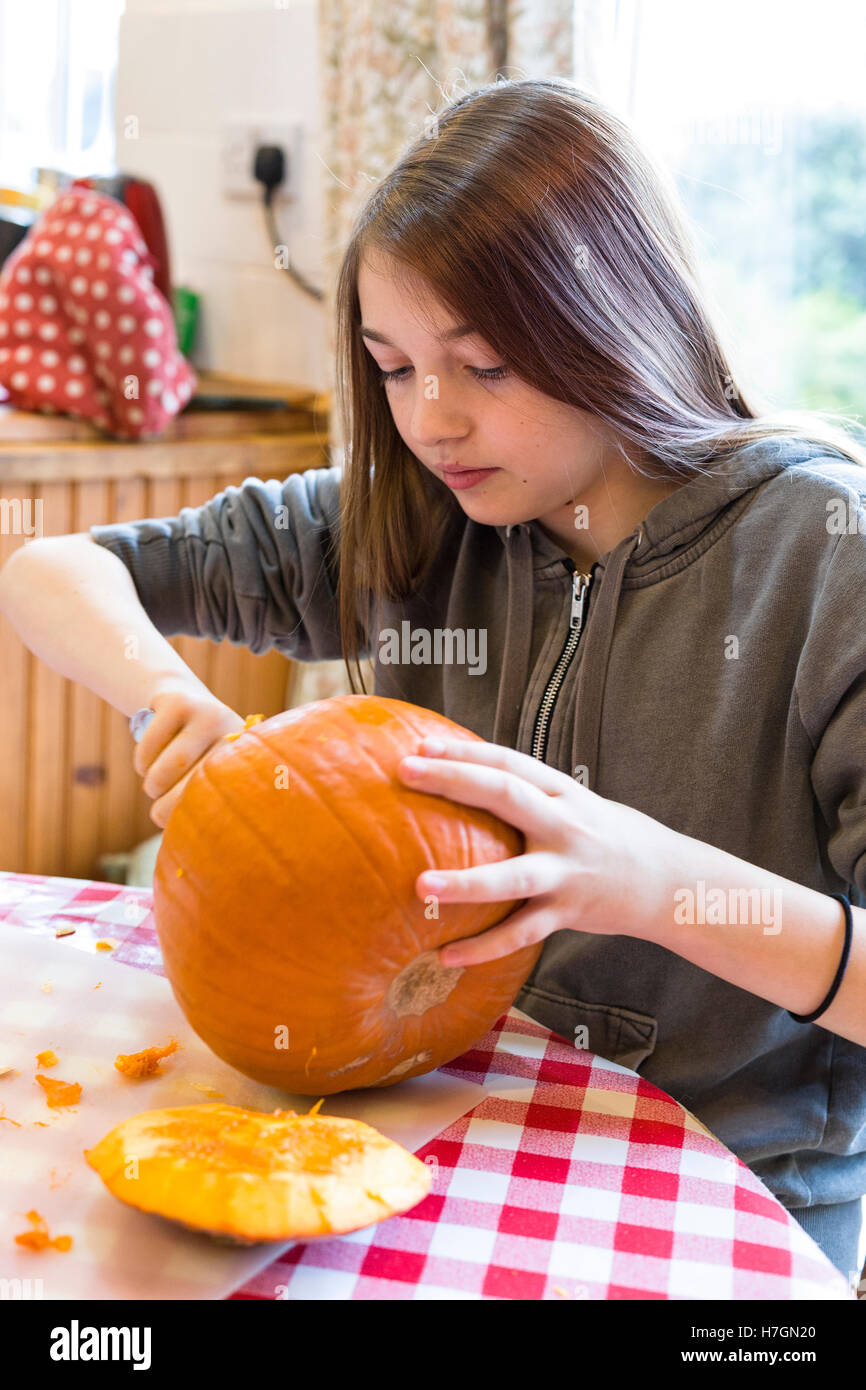 Jeune fille sculpter une citrouille à l'Halloween modèle libération : Oui. Biens : Non. Banque D'Images