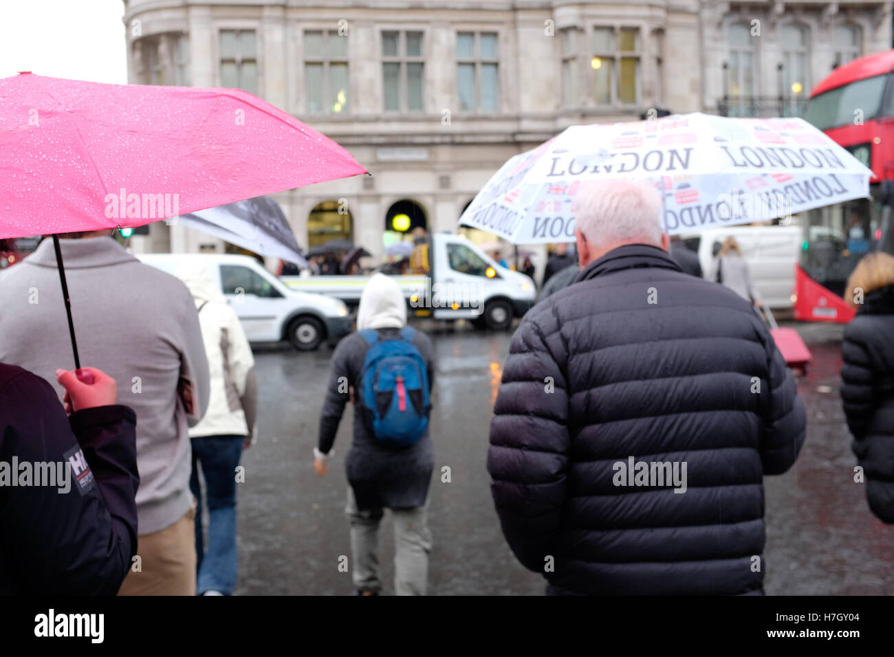 Londres, Angleterre, Royaume-Uni, le plus sec après 65 ans en octobre, les touristes à l'extérieur du palais de Westminster en plastique sport mac et flaques leap vendredi à la pluie. Credit : d-mark/Alamy Live News Banque D'Images