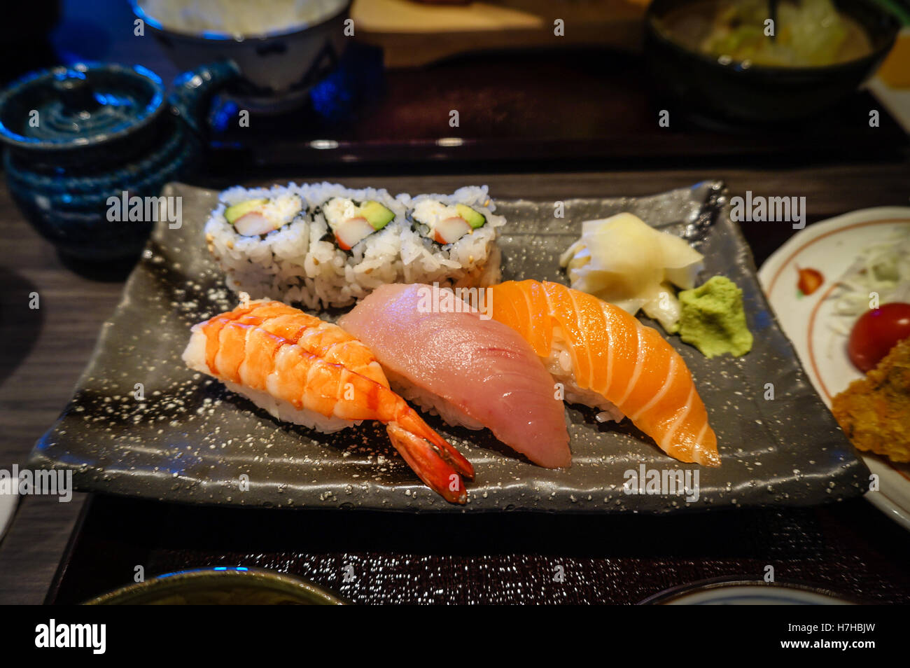 Assiette de sushis nigiri avec Ebi (crevettes), Maguro (thon) et Sake (saumon) dans une salle à manger japonais. Banque D'Images