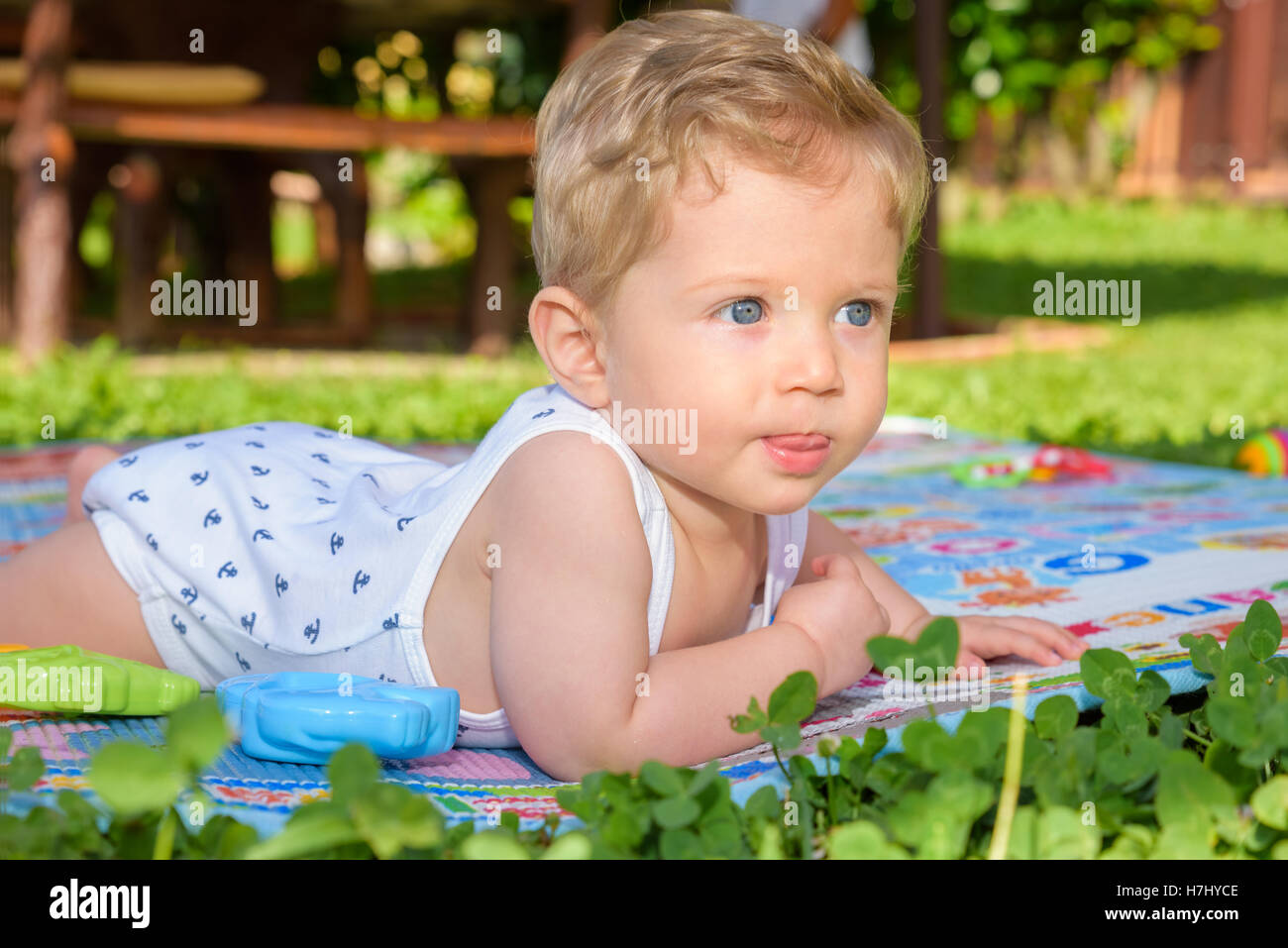 Magnifique petit garçon de huit mois à ramper dans le jardin,close up. Banque D'Images