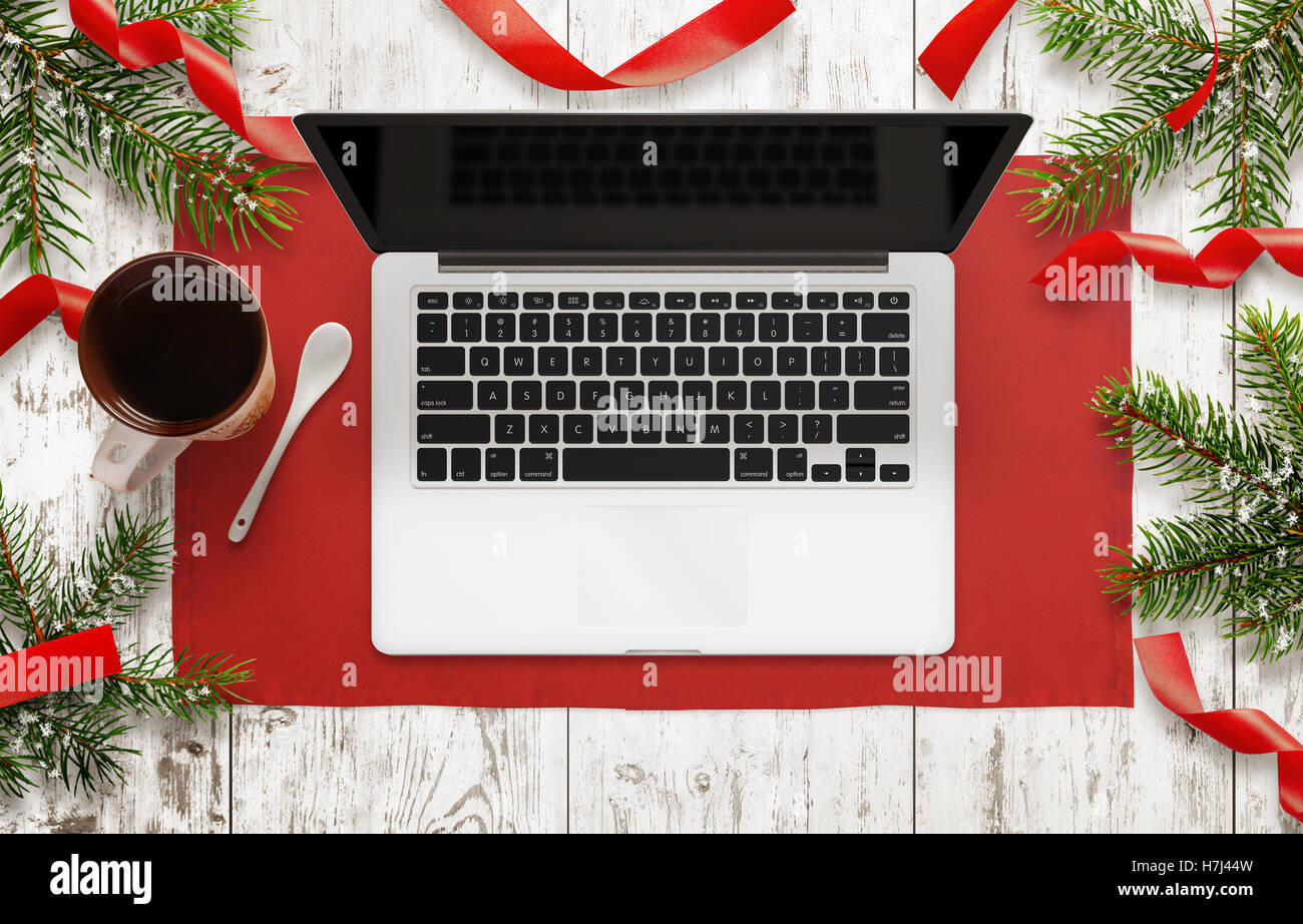 Ordinateur portable sur la table avec des décorations de Noël à côté. Vue de dessus de table avec nappe, arbre de Noël, bande décorative Banque D'Images