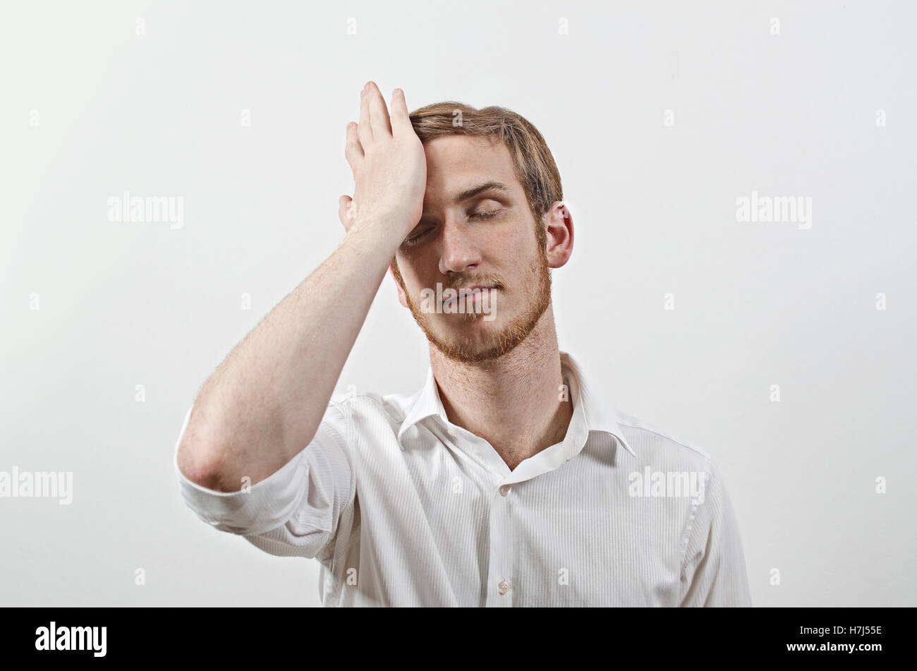 Les jeunes adultes de sexe masculin de porter une chemise blanche aux gestes qu'il a fait une grosse erreur Banque D'Images
