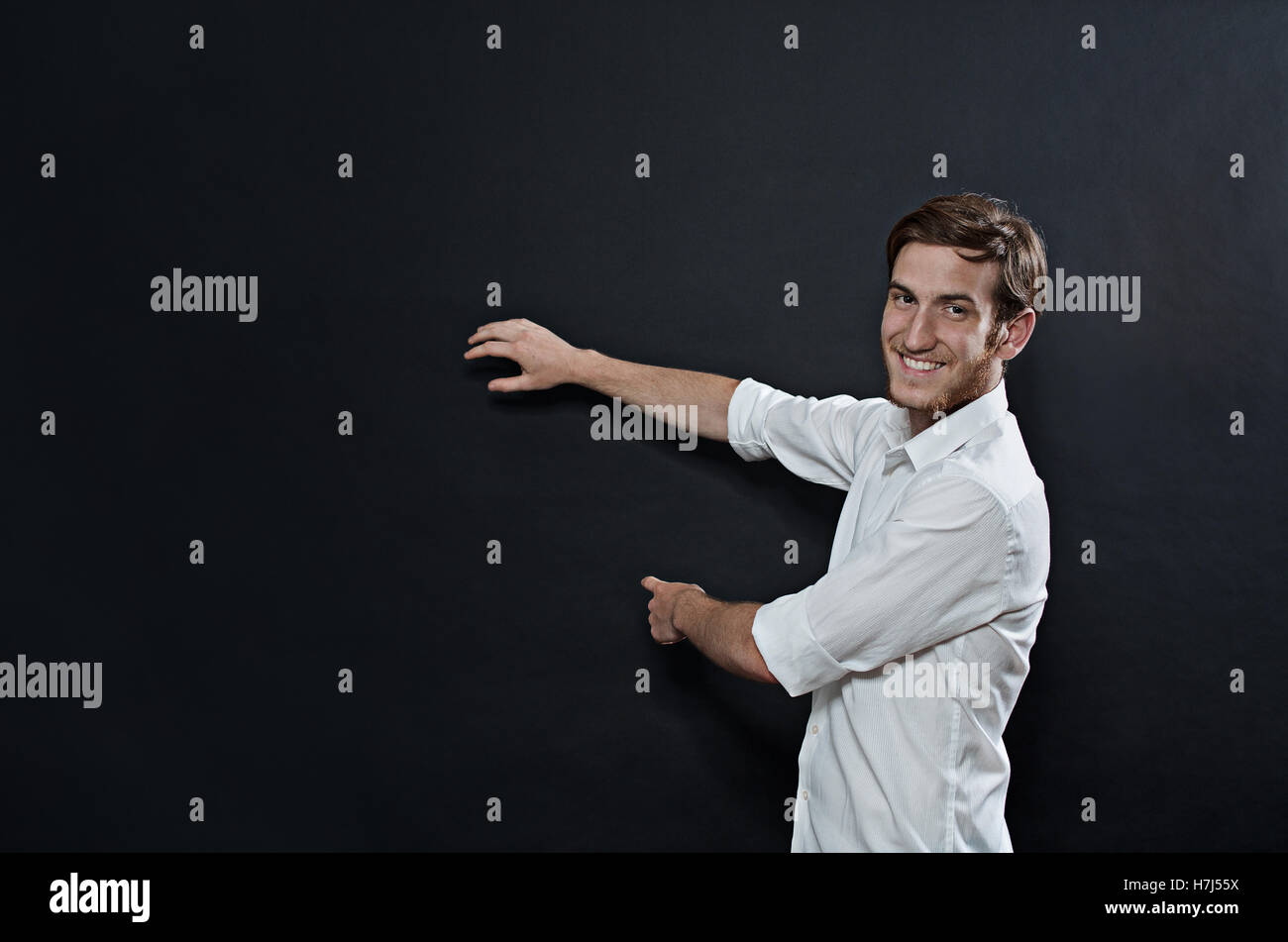 Les jeunes adultes de sexe masculin en chemise blanche Gesturing, montrant, de l'enseignement Banque D'Images