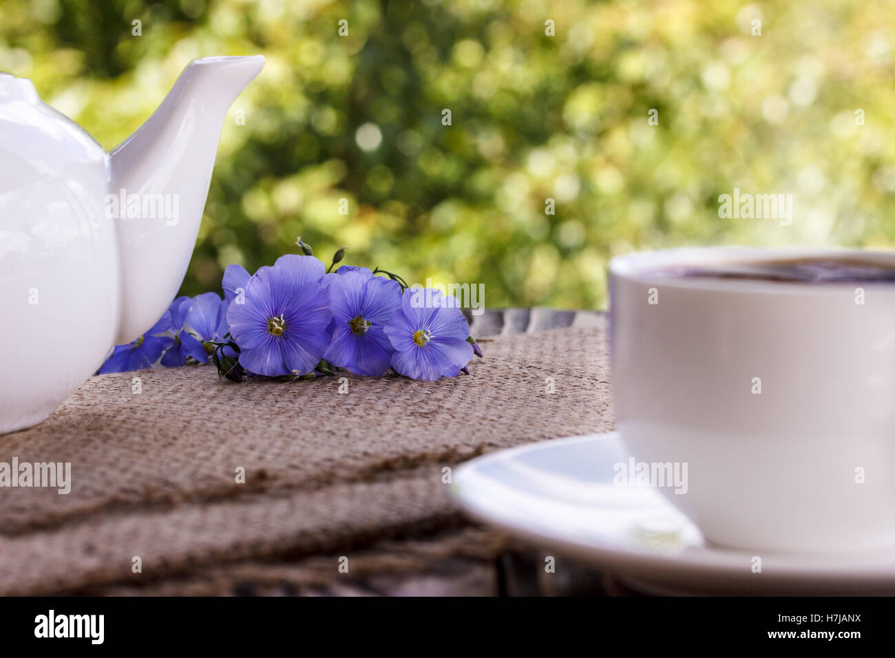 Tasse à café avec fleurs bleues et note qu'une bonne matinée sur bleu au-dessus de table rustique, petit déjeuner Banque D'Images