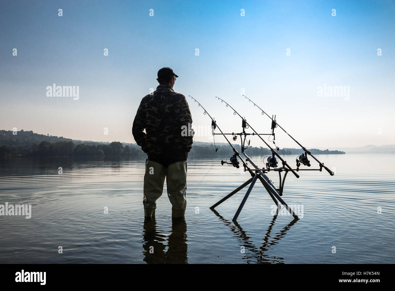 Aventures de pêche. Pêcheur, avec de hautes bottes de pêche, attendant d'attraper un poisson avec la technique de pêche de la carpe Banque D'Images