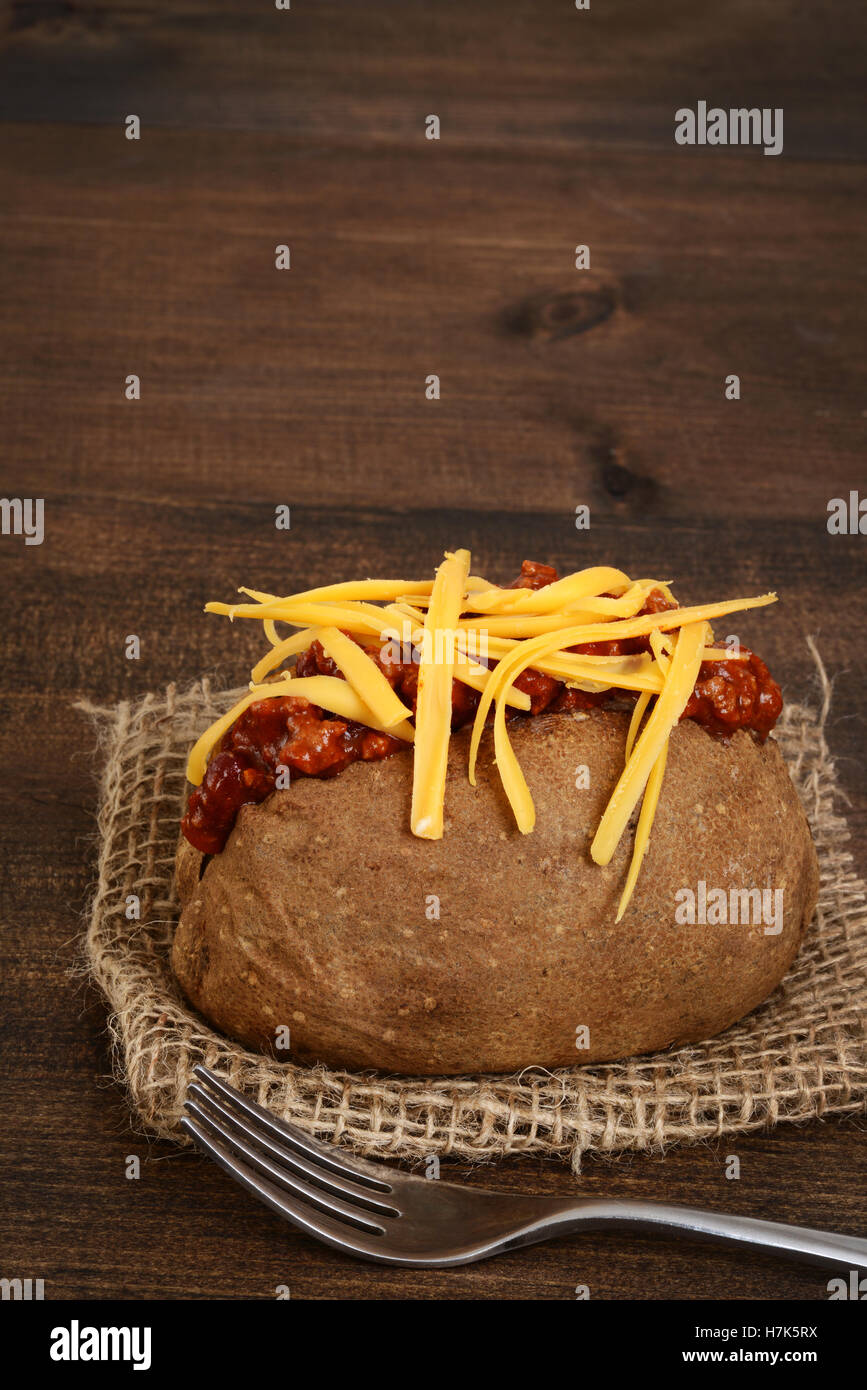 Pomme de terre au four avec du fromage et une fourchette de chili Banque D'Images