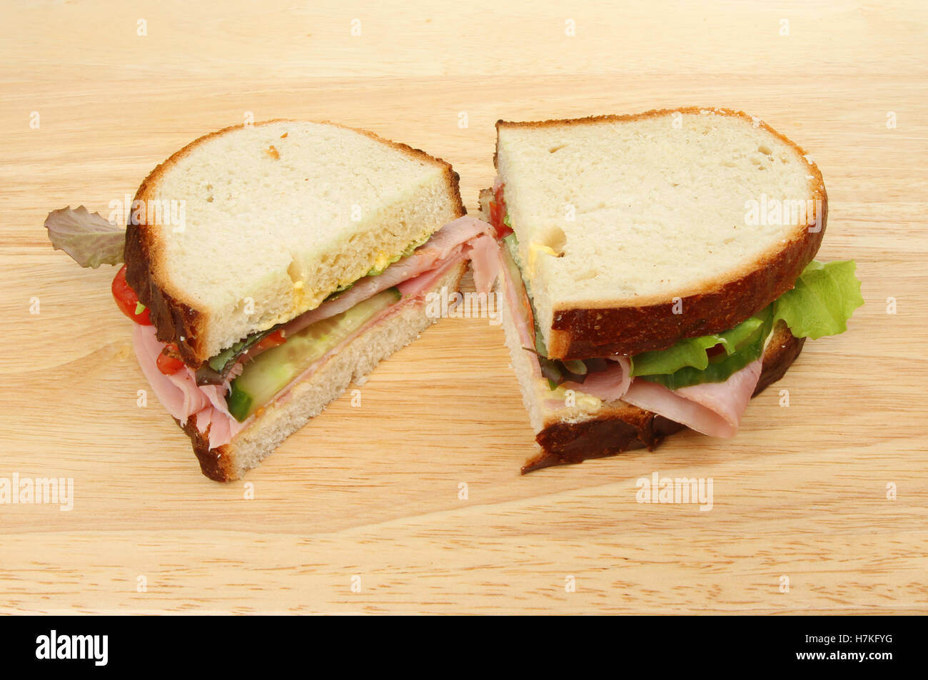 Sandwich à la salade de jambon sur une demi-planche à découper en bois Banque D'Images