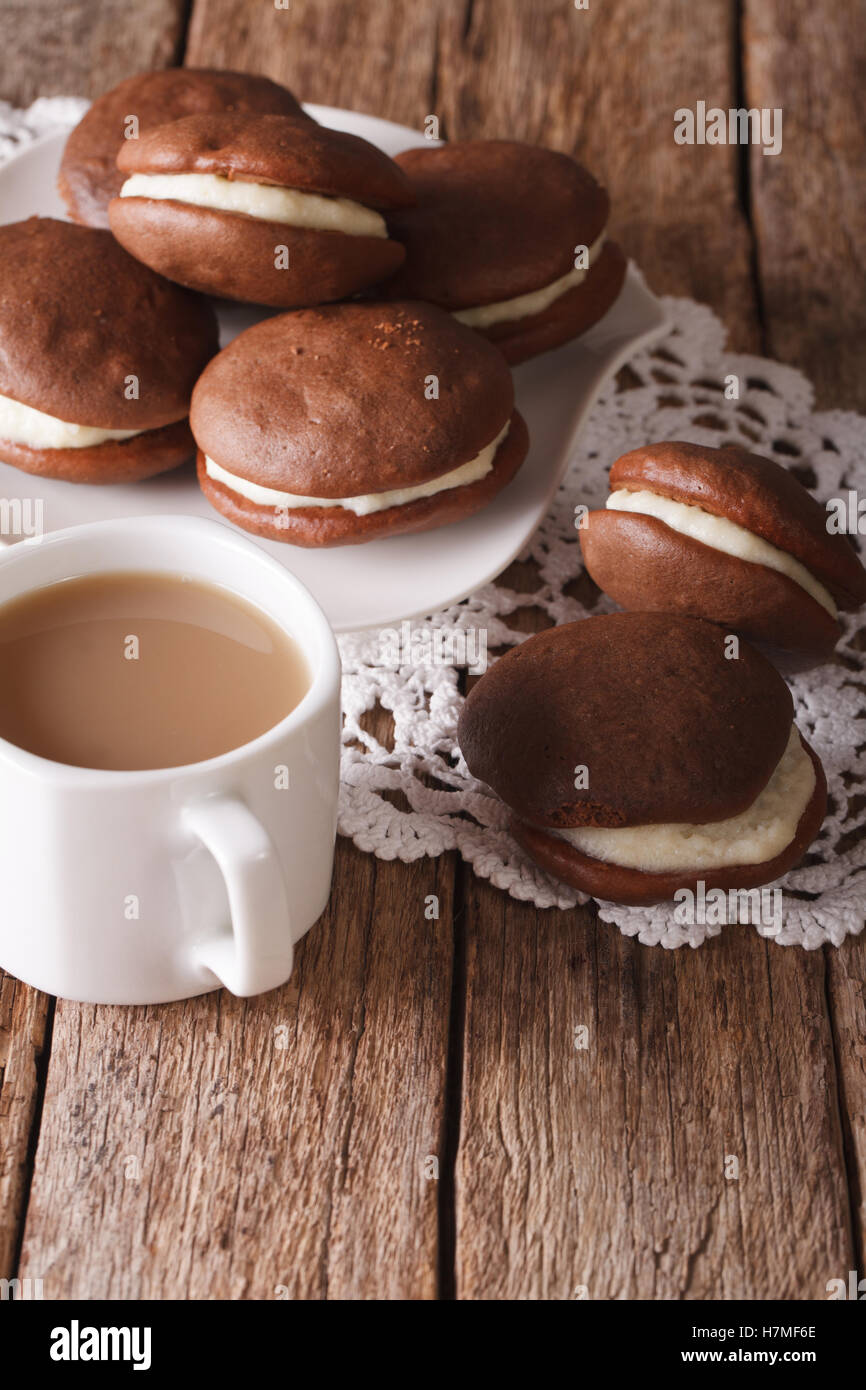 Whoopie pie au chocolat et café au lait sur la table verticale. Banque D'Images