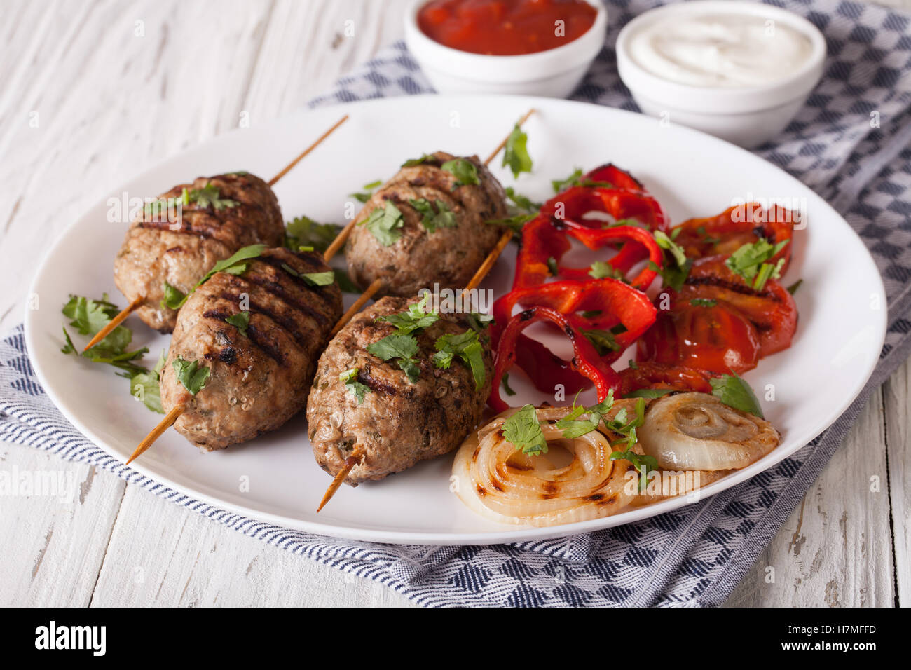 Kofta délicieux kebab avec légumes grillés sur une assiette et la sauce sur la table horizontale. Banque D'Images