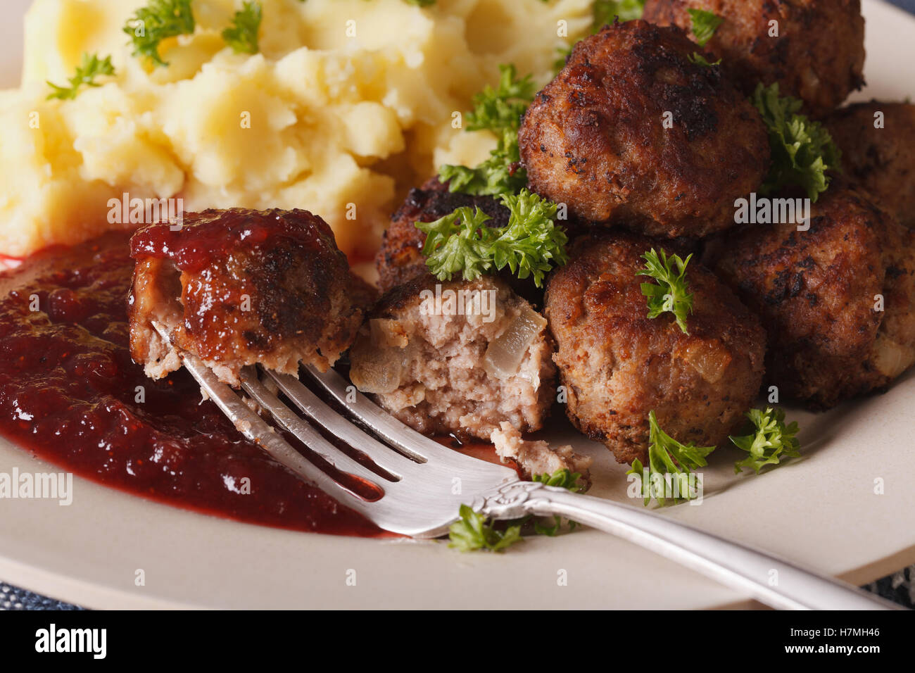 Kottbullar alimentaire suédois : boulettes sauce aux airelles, et écrasé de pommes de terre sur une plaque horizontale de macro. Banque D'Images