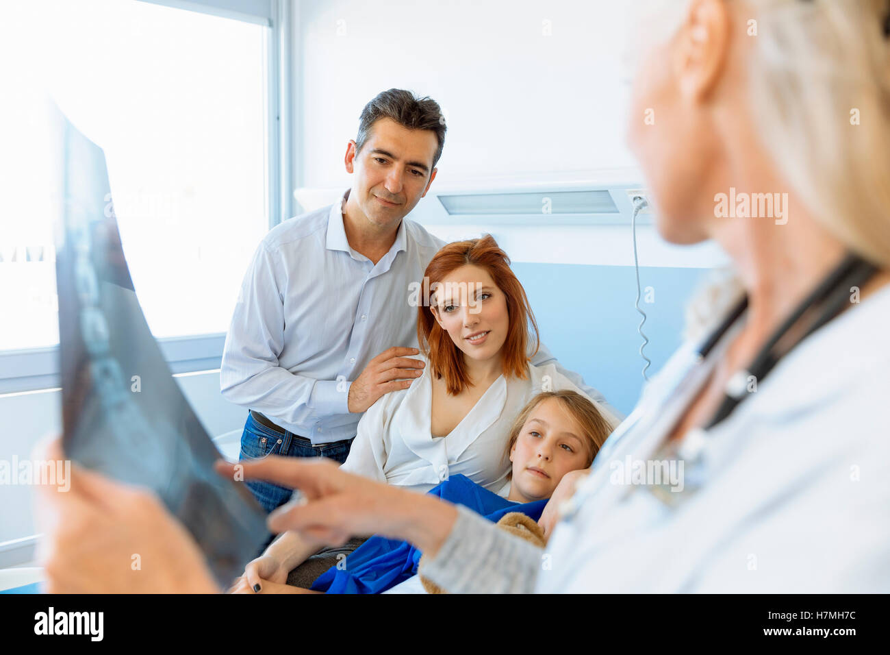 Pédiatre Visiter parents et enfant en lit d'hôpital Banque D'Images